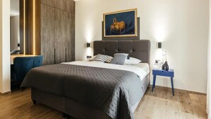 A modern bedroom with a large bed, a desk, and a painting on the wall. - Luxury Villa Lara With Heated Pool, Hot-tub and Sauna - Six Bedroom Villa With Pool (Zmijavci)