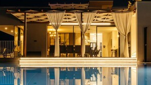 A modern hotel with a pool, indoor dining area, and a well-lit entrance. - Luxury Villa Lara With Heated Pool, Hot-tub and Sauna - Six Bedroom Villa With Pool (Zmijavci)