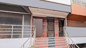 Una escalera conduce a la entrada de un edificio, con barandillas metálicas a ambos lados.