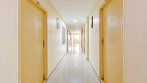 Un largo y estrecho pasillo con puertas a ambos lados, cada una con un número.