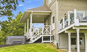 A two-story house with a covered porch and a small deck.