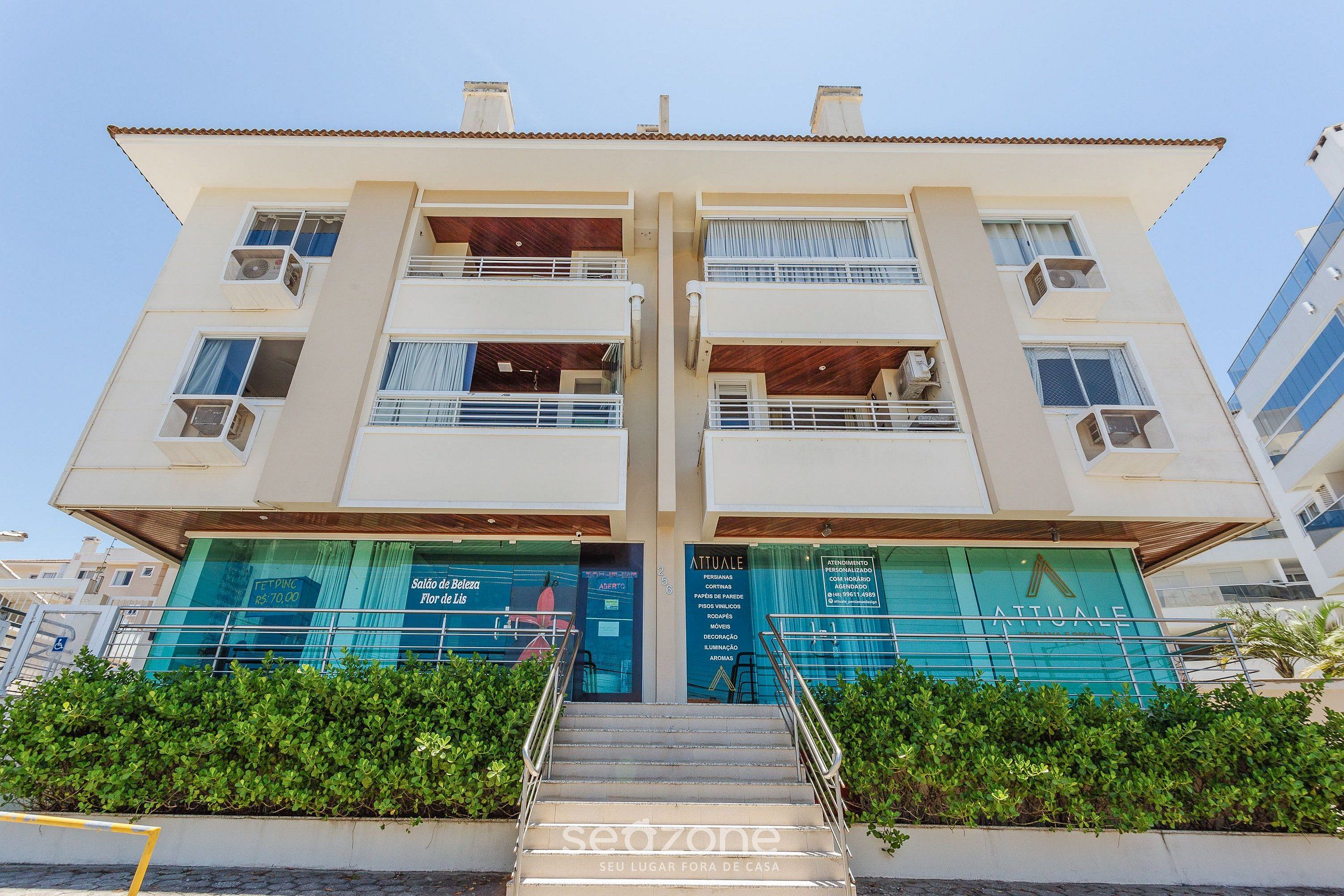 A multi-story hotel with balconies, a staircase, and signage for amenities.