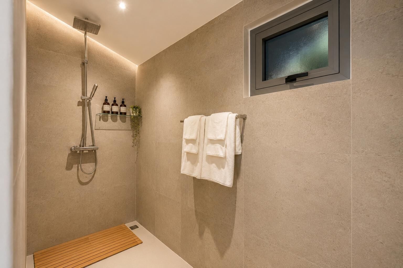 Uma área de chuveiro moderna com um nicho de vidro contendo artigos de higiene pessoal, um porta-toalhas com uma toalha branca e uma pequena janela.
