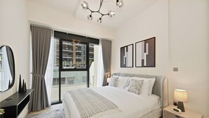 A modern hotel room with a large bed, a bedside table with a lamp, a mirror, and a view of the outside. - Bloomfields 2BR in Azizi Riviera 43 (Dubai)