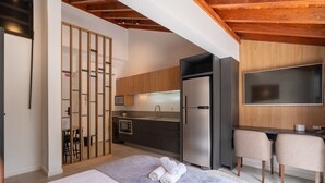 A modern bedroom with a bed, a desk, and a kitchenette. - Studio With Private Balcony in Floripa Cma0201 (Florianópolis)