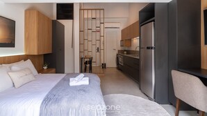 A modern hotel room with a neatly made bed, a small kitchenette, and a seating area. - Studio With Private Balcony in Floripa Cma0201 (Florianópolis)