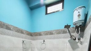 Une salle de bain comprenant des toilettes, un lavabo et un espace douche.