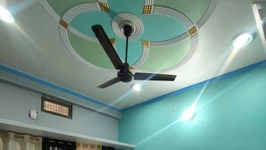 Une chambre à coucher avec un lit, des rideaux, un ventilateur de plafond et une fenêtre également dotée de rideaux.