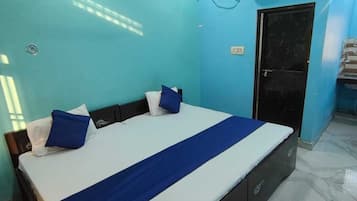 Un dormitorio con cama, ventilador de techo, aire acondicionado y una puerta.