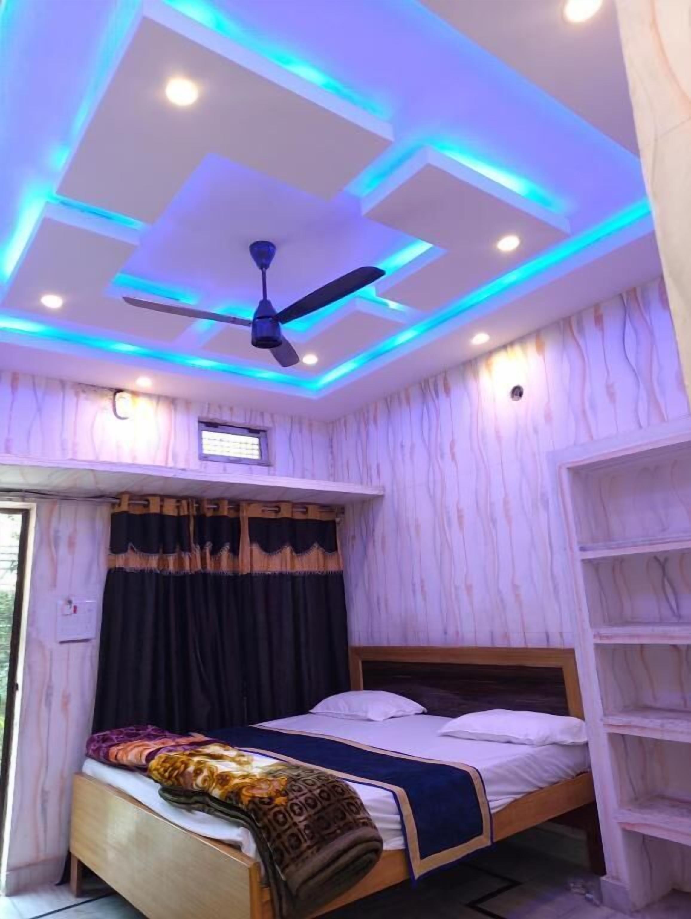 Ein Schlafzimmer mit einem Bett, einem Deckenventilator und einem Regal.