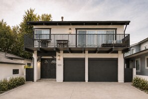A modern two-story house with a balcony, a garage, and a number '121' on the door. - NEW Huge Family Beach House in Silver Strand (Oxnard)