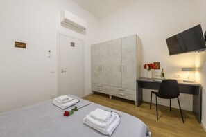 A bedroom with a bed, a desk, a chair, a wardrobe, and a television. - Sabotino, 16 – Milan Vibes (Milano)