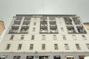 A multi-story building with balconies, a ground-floor entrance, and several visible signs including a hotel and a spa. - Sabotino, 16 – Milan Vibes (Milano)