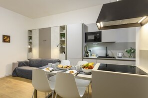 A compact living space with a kitchenette, a dining area, and a sofa. - Sabotino, 16 – Milan Vibes (Milano)