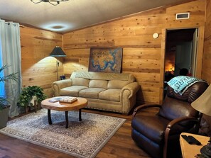 A cozy living room with a sofa, a chair, a coffee table, and a map on the wall. - Gated property - 3 bedroom 2 bath plenty of room for your toys (Kingston)