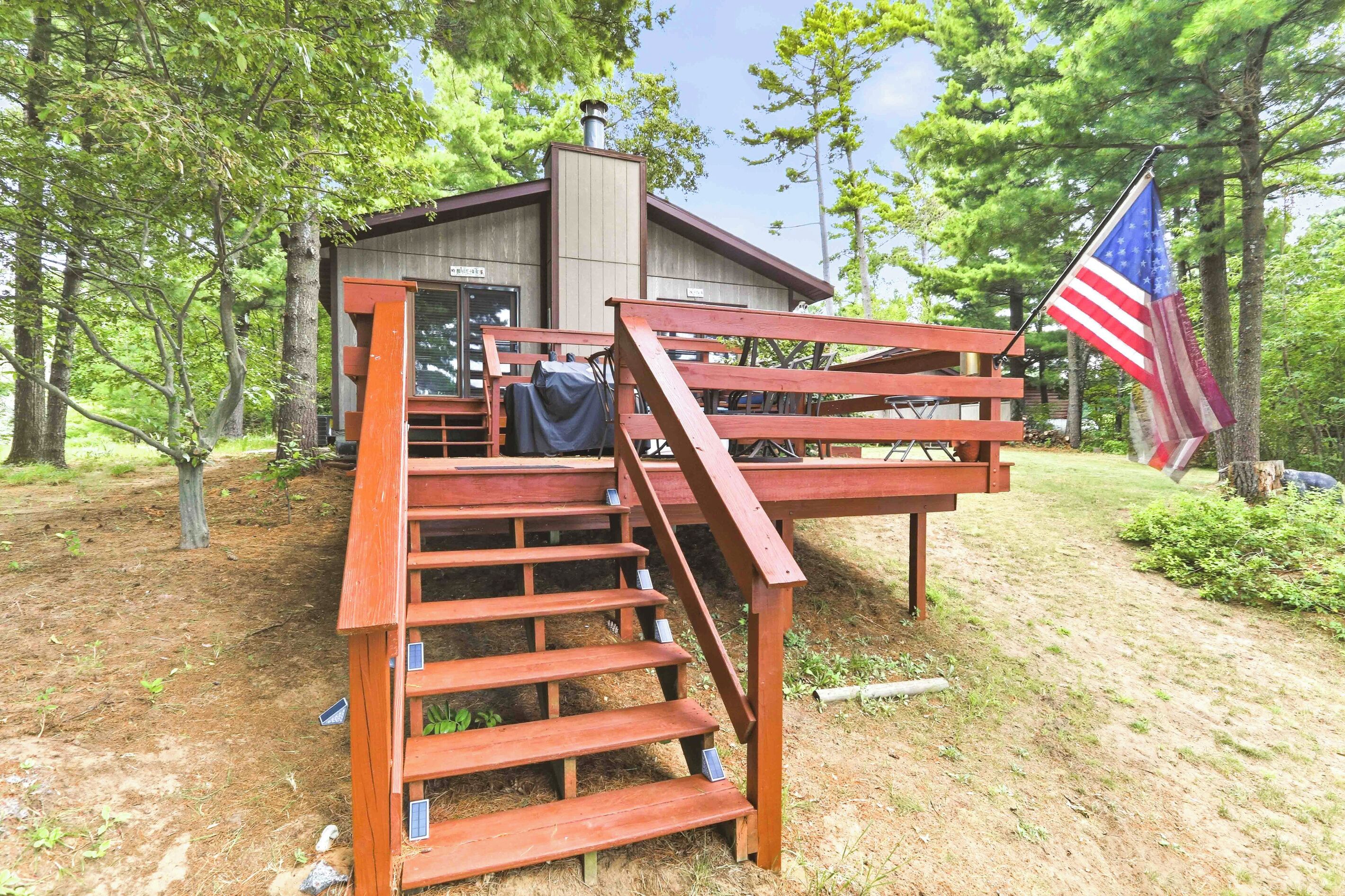 Eine Holztreppe führt zu einer Hütte mit einer Flagge.