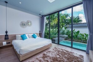 Ein modernes Schlafzimmer mit einem großen Bett, Blick auf einen Swimmingpool und einer Deckenleuchte.