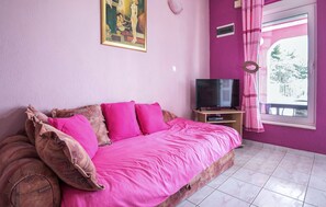 A bedroom with a bed, a television, and a window with curtains. - Amazing apartment in Trogir with swimming pool (Trogir)