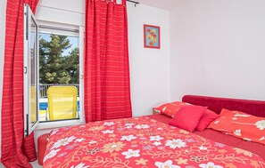 A bedroom with a bed, red curtains, a window, and a yellow chair outside. - 3 bedroom amazing apartment in Split (Split)
