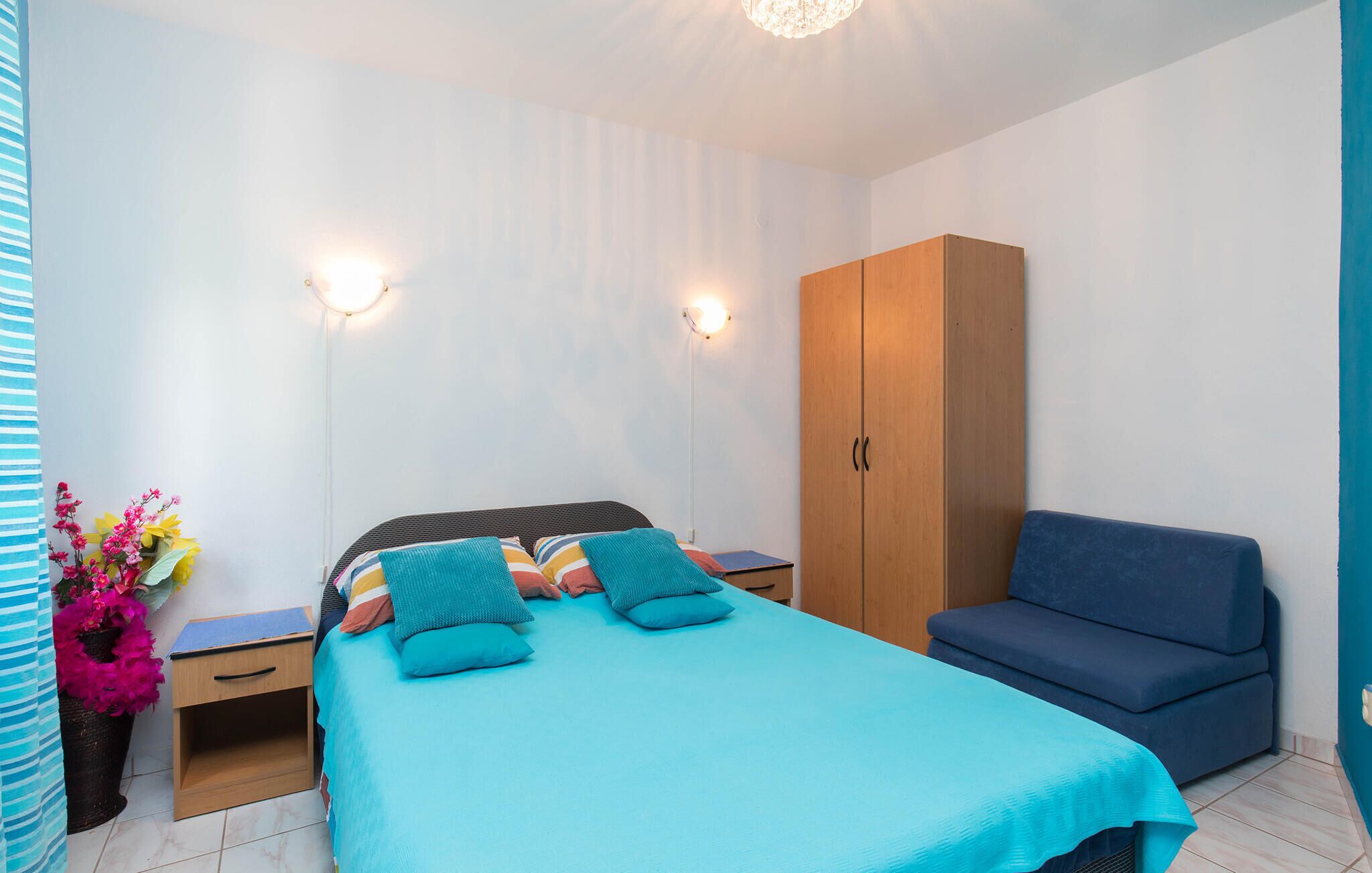 Une chambre à coucher comprenant un lit, des tables de chevet, une armoire et un canapé.