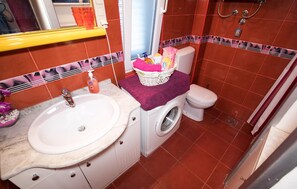 A compact bathroom with a sink, toilet, and washing machine. - Beautiful apartment in Trogir (Trogir)