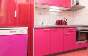 A kitchen with pink cabinets, a stainless steel oven, and a kettle on the counter. - Beautiful apartment in Trogir (Trogir)