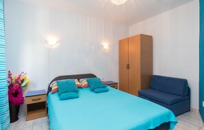 A bedroom with a bed, a wardrobe, a bedside table, and a sofa. - Lovely apartment in Seget Vranjica with WiFi (Seget Vranjica)