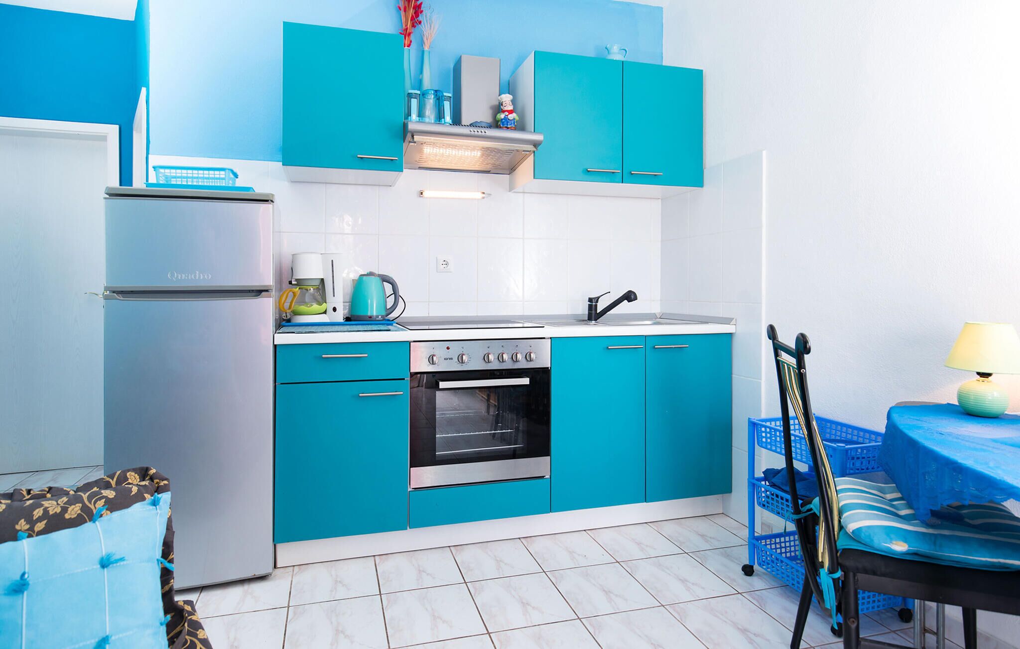 Une cuisine de taille réduite équipée d’un réfrigérateur, d’une cuisinière, d’un four et d’un évier.