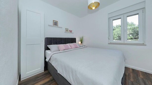 A bedroom with a bed, a window, a door, and a hanging light fixture. - Pet friendly home in Ervenik (Ervenik)