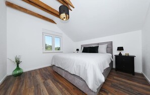 A bedroom with a bed, bedside tables, a window, and wooden beams on the ceiling. - Pet friendly home in Ervenik (Ervenik)