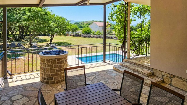 A covered patio with a pool, stone pillar, and outdoor seating. - Awesome home in Ervenik (Ervenik)