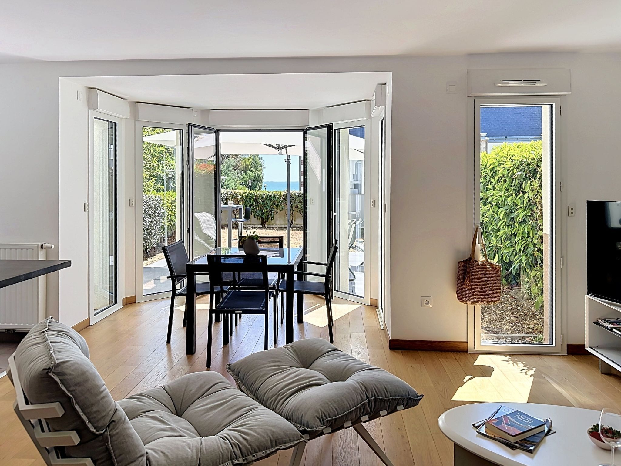 Una sala moderna con comedor, un sofá, una mesa de centro y un televisor.