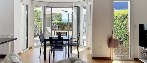A modern living room with a dining area, a sofa, a coffee table, and a TV.