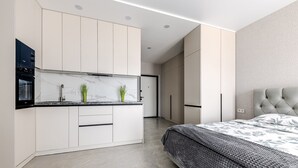 A modern bedroom with a bed, a nightstand, and a built-in wardrobe.
