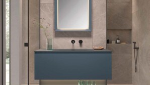 Un baño moderno con lavamanos integrado, espejo y zona de ducha.