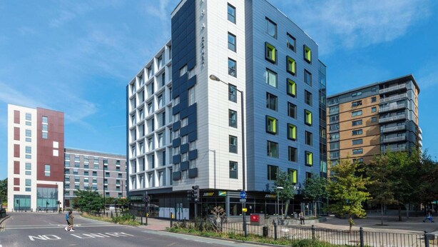A modern building with multiple floors, a Subway restaurant at the ground level, and a pedestrian crossing. - Student Only The Lyra (London)