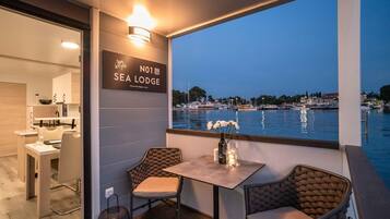Un comedor con vistas al mar, un cartel que dice 'Sea Lodge' y una mesa con sillas.