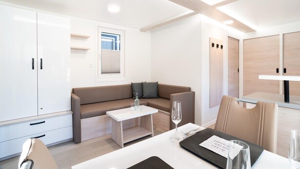 Une pièce moderne et bien éclairée, avec un canapé, une petite table et un coin repas.