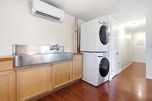 A laundry room with a stainless steel sink, a washing machine, and a dryer. - Waterfront - Sauna -Steps To Beach! (Saco)
