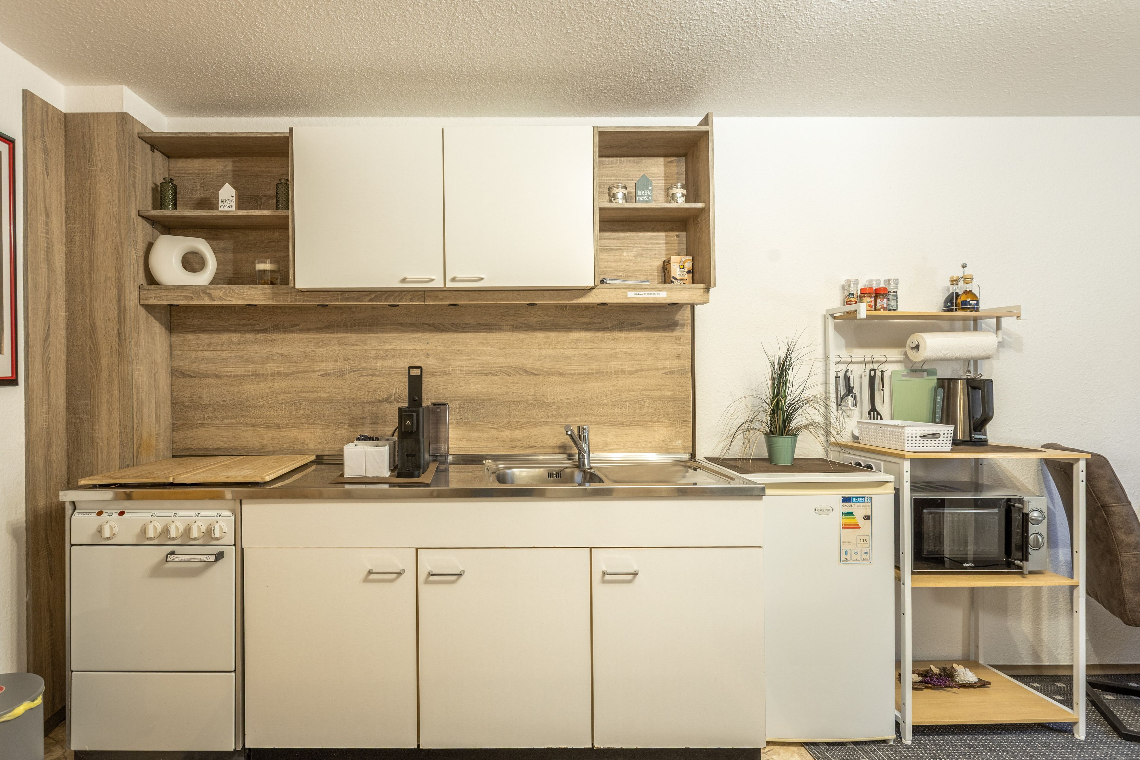 Une petite cuisine équipée d’une cuisinière, d’un évier et d’un four à micro-ondes.