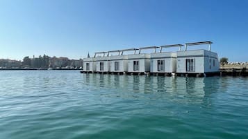 Una hilera de casas flotantes con una vista despejada del agua y una costa lejana.