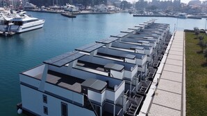 A waterfront property with multiple buildings, a marina with boats, and a pedestrian walkway. - Dream houseboat with sea view and hot tub (Novigrad)