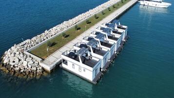 A waterfront property with a series of connected buildings, a dock, and a row of boats.