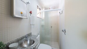 A bathroom with a granite countertop sink, a white toilet, a glass-enclosed shower, and a mirror above the sink. - Apt in a Seaside Condominium With a Pool - Gsh2101 (Camaçari)