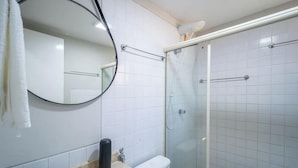 A bathroom with a toilet, a sink, a mirror, and a glass-enclosed shower area. - Apt in Condo With Pool Near the Beach Gsh0101 (Camaçari)