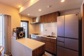 Une cuisine moderne équipée d’un lave-vaisselle intégré, d’une cuisinière et d’un réfrigérateur à deux portes.