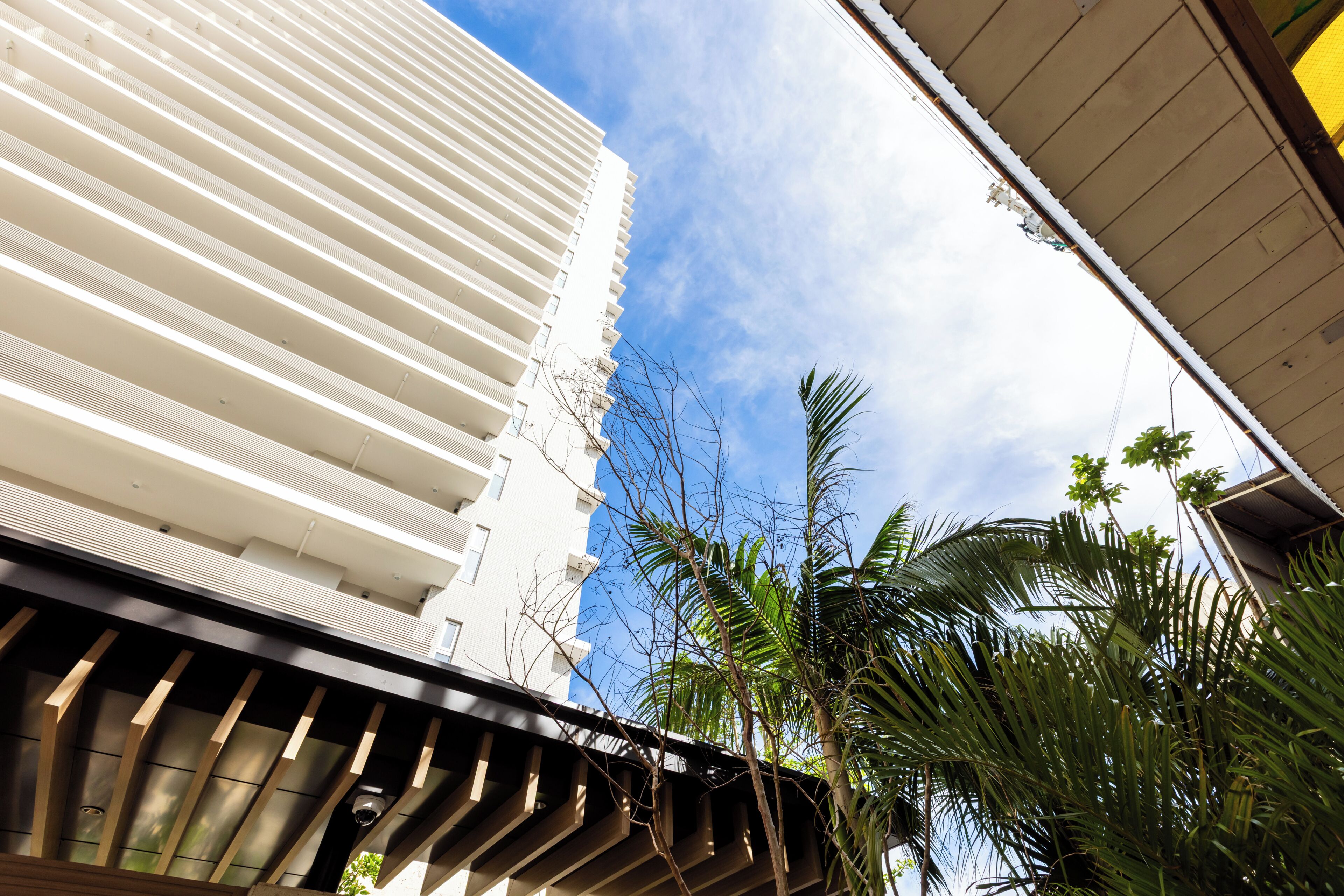 A modern building with a white facade and a series of balconies.