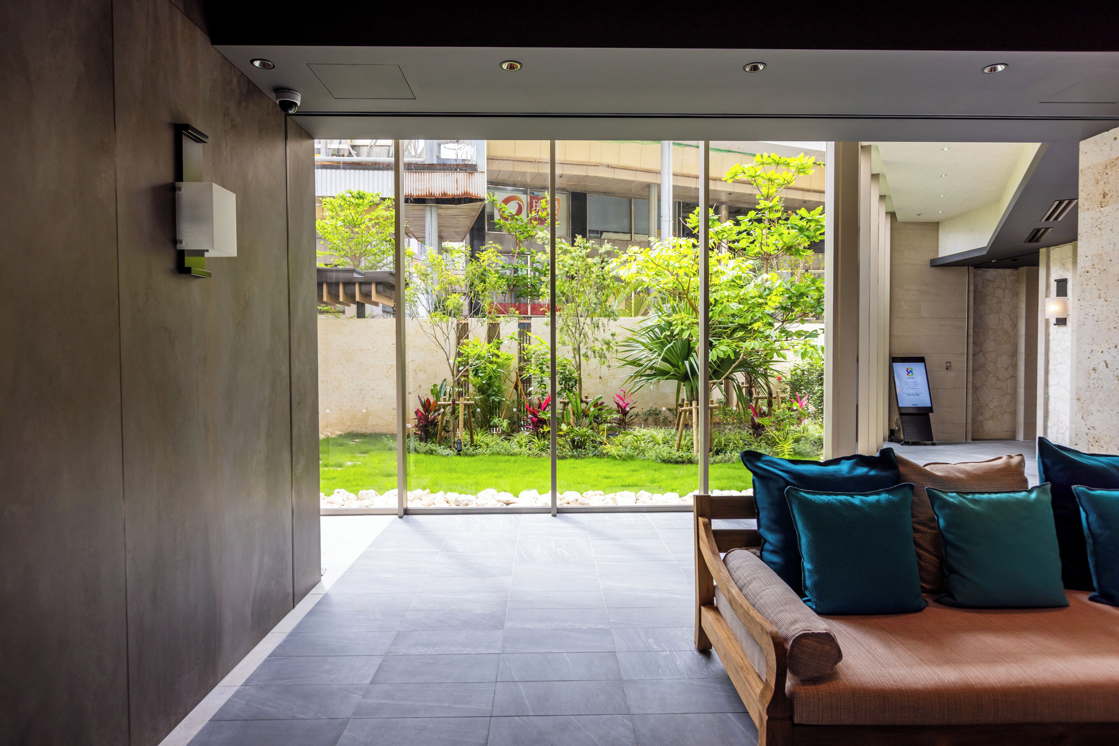 Un interior moderno con un muro de vidrio corredero que da a un jardín.