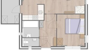Plano de un cuarto de hotel con cama, una zona de estar con sofá y sillas, una pequeña cocina y un baño.