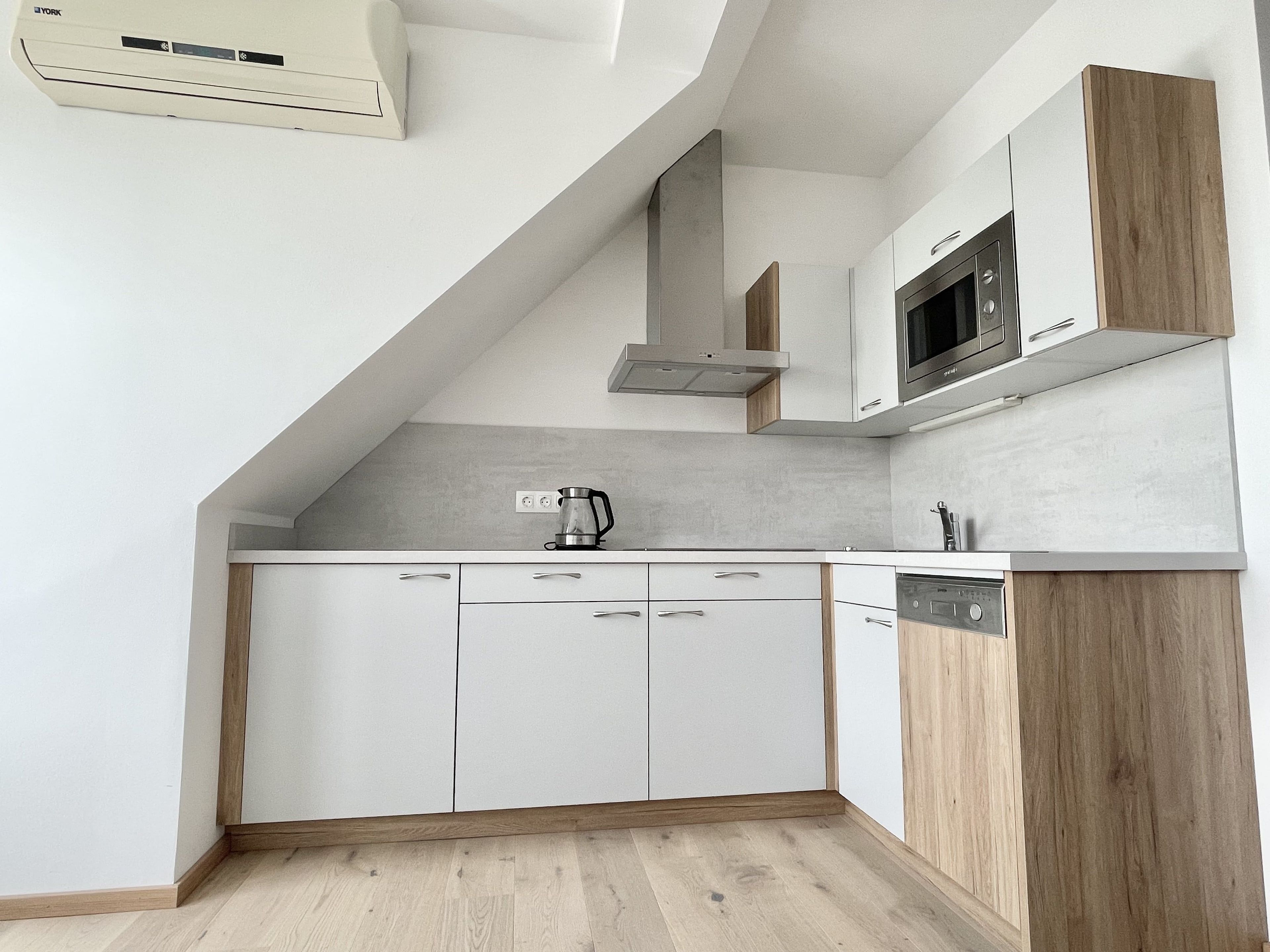 A modern kitchen with white cabinetry, a built-in microwave, and a dishwasher.